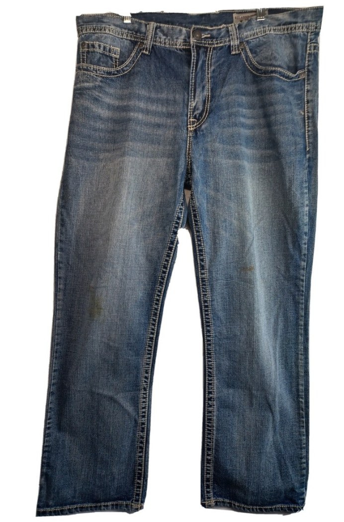 Men's relaxed fit blue jeans with heavy whiskering and contrast stitching, laid flat on white background
